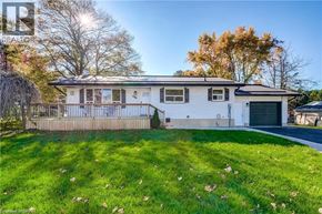 Palmerston apartment for rent - A house with a white exterior and a grey roof is surrounded by a green lawn.