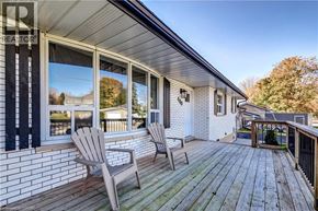 Palmerston apartment for rent - A wooden deck with two chairs and a table is in front of a house.