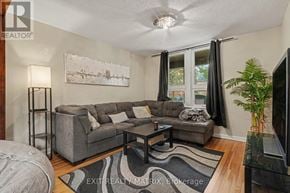 Ottawa duplex for rent - A living room with a grey couch and a painting on the wall.