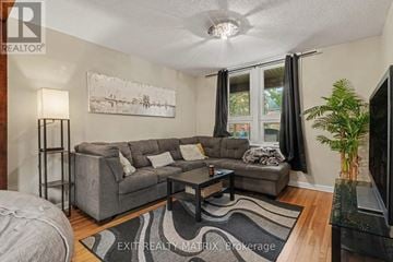 Ottawa duplex for rent - A living room with a grey couch and a painting on the wall.