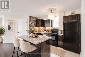 Toronto (Church-Yonge Corridor) condo for rent - A modern kitchen with a marble island and black appliances.