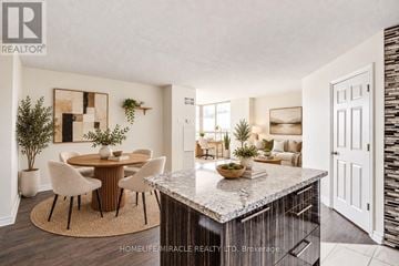 Toronto (Church-Yonge Corridor) condo for rent - A modern kitchen with a marble countertop and a dining area with a round table and chairs.