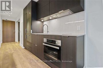 Toronto (Waterfront Communities) condo for rent - A modern kitchen with dark wood cabinets and stainless steel appliances.