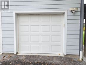 East Gwillimbury triplex for rent - A white garage door is closed and appears to be brand new.