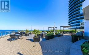 Toronto (Mimico) condo for rent - A balcony with a table and chairs overlooking the sea.