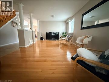 Cambridge apartment for rent - A living room with a black couch and a wooden floor.