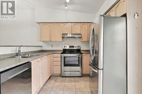 Oakville (Ga Glen Abbey) condo for rent - A kitchen with a refrigerator, sink, and stove.