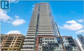 Mississauga (City Centre) condo for rent - A tall building with a blue sky in the background.