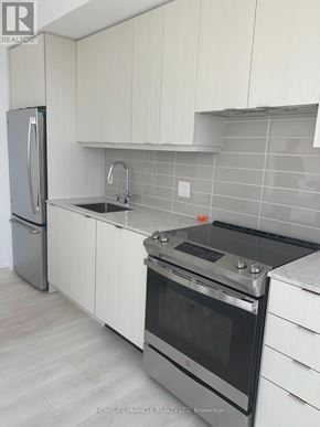 Mississauga (City Centre) condo for rent - A kitchen with white cabinets and a stainless steel refrigerator.