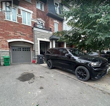 Brampton (Heart Lake East) townhouse for rent - A black car is parked in front of a red brick building.