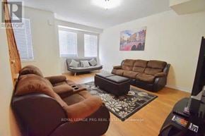 Brampton (Heart Lake East) townhouse for rent - A living room with a brown couch and a television.