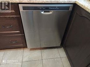 Brampton (Heart Lake East) townhouse for rent - A dishwasher is placed in a kitchen with brown cabinets.