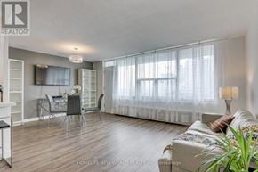 Toronto (Henry Farm) condo for rent - A living room with a dining table and chairs, a couch, and a television.