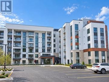 Milton (Walker) condo for rent - A large, modern apartment complex with a parking lot in front.