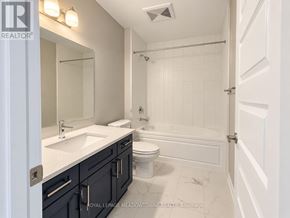 Milton (Walker) condo for rent - A white bathroom with a toilet, sink, and shower.