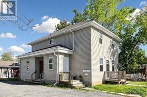 Kawartha Lakes (Lindsay) triplex for rent - A small house with a porch and a fence in front.