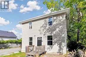 Kawartha Lakes (Lindsay) triplex for rent - A small house with a porch and a fence in front.