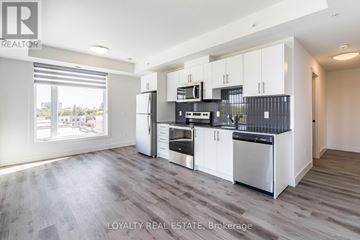 Waterloo condo for rent - A modern kitchen with white cabinets and stainless steel appliances.