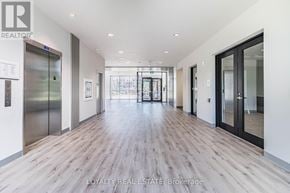 Waterloo condo for rent - A hallway with wood floors and glass doors leading to a balcony.
