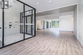 Waterloo condo for rent - A spacious room with wooden flooring and glass walls.