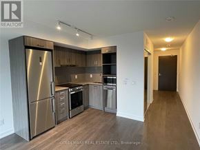 Toronto (Church-Yonge Corridor) condo for rent - A kitchen with stainless steel appliances and wooden cabinets.
