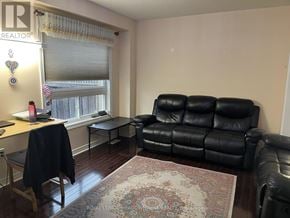 Milton (Cl Clarke) townhouse for rent - A black leather couch sits in a living room with a rug on the floor.