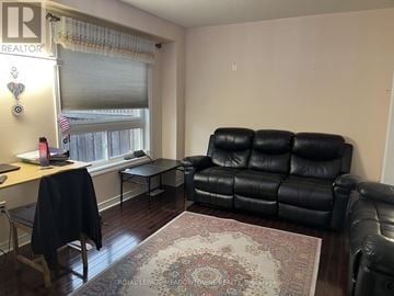 Milton (Cl Clarke) townhouse for rent - A black leather couch sits in a living room with a rug on the floor.
