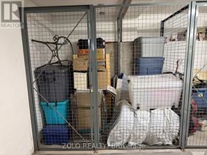 Ottawa condo for rent - A storage unit is full of various items including a blue container, a white bag, and a black suitcase.