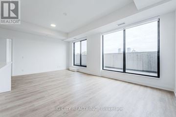 Toronto (Thorncliffe Park) condo for rent - A spacious room with a large window and wooden flooring.