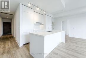 Toronto (Thorncliffe Park) condo for rent - A spacious kitchen with white cabinets and a large island.