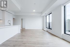 Toronto (Thorncliffe Park) condo for rent - A spacious, empty room with a large window and a wooden floor.
