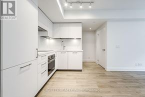 Toronto (Thorncliffe Park) condo for rent - A white kitchen with a wooden floor and white cabinets.