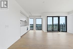 Toronto (Thorncliffe Park) condo for rent - A spacious room with a view of the city through large windows.