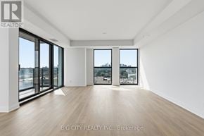 Toronto (Thorncliffe Park) condo for rent - A spacious room with wooden floors and large windows overlooking a cityscape.