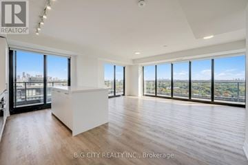 Toronto (Thorncliffe Park) condo for rent - A spacious room with a large window overlooking a cityscape.