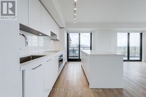 Toronto (Thorncliffe Park) condo for rent - A modern kitchen with white cabinets and a view of the city.