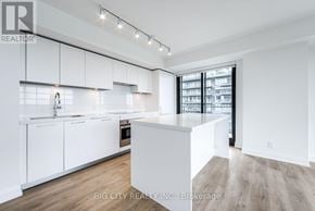 Toronto (Thorncliffe Park) condo for rent - A modern kitchen with white cabinets and a wooden floor.