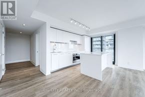 Toronto (Thorncliffe Park) condo for rent - A spacious kitchen with white cabinets and a wooden floor.