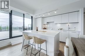 Toronto (Thorncliffe Park) condo for rent - A modern kitchen with white cabinets and a large island.