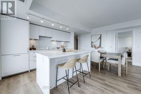 Toronto (Thorncliffe Park) condo for rent - A modern kitchen with white cabinets and a wooden floor.