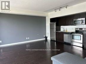 Toronto (South Parkdale) condo for rent - A kitchen with a refrigerator, microwave, and oven.