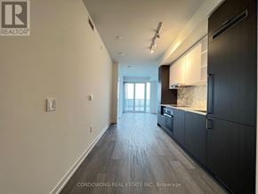 Toronto (Waterfront Communities) condo for rent - A spacious kitchen with dark wood cabinets and a marble backsplash.