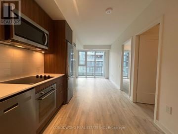 Toronto (Waterfront Communities) condo for rent - A kitchen with a stove top oven and microwave above it.