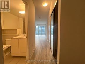 Toronto (Waterfront Communities) condo for rent - A hallway with a white cabinet and a toilet in the corner.