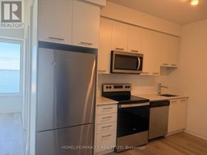 Grimsby (Grimsby Beach) condo for rent - A kitchen with a refrigerator, microwave, oven, and sink.