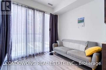 Toronto (Church-Yonge Corridor) condo for rent - A living room with a grey couch and a window with curtains.