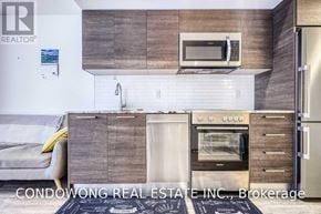 Toronto (Church-Yonge Corridor) condo for rent - A modern kitchen with a microwave above the oven and a refrigerator to the right.