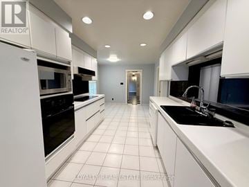 Markham (Bayview Glen) apartment for rent - A white kitchen with a black stove top oven.