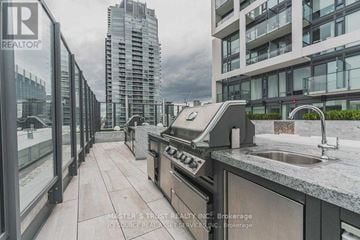Toronto (Mount Pleasant West) condo for rent - A modern kitchen with a stainless steel refrigerator and a view of a cityscape.