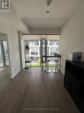 Toronto (Mount Pleasant West) condo for rent - A room with a wooden floor and a large window with a view of a city.